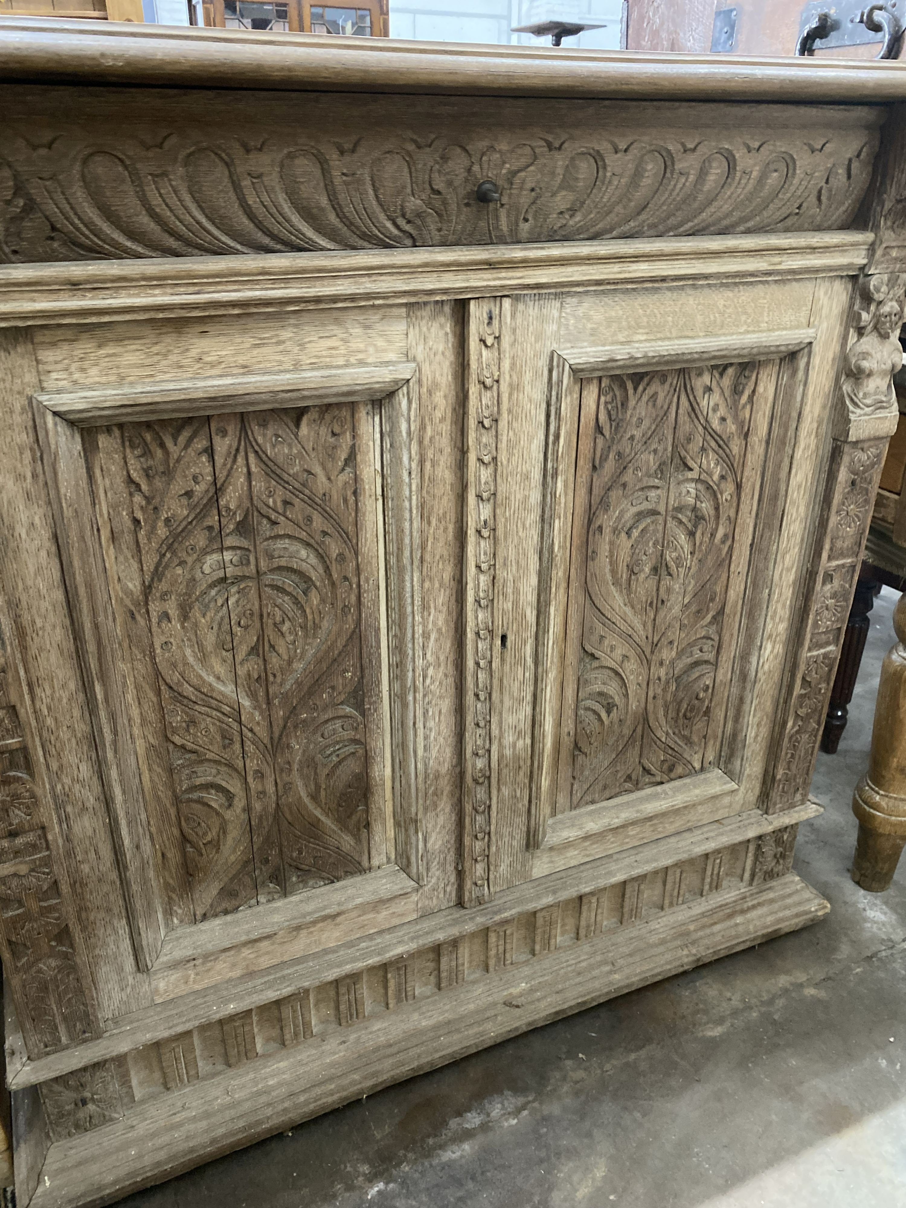 A late 19th century Flemish carved bleached oak two door side cabinet, width 106cm, depth 50cm, height 104cm